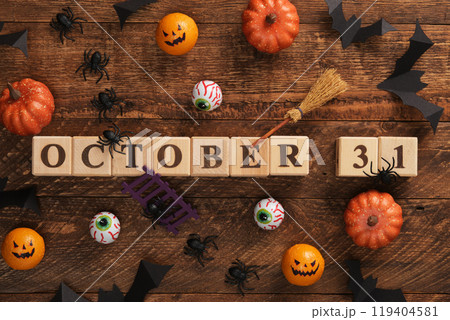 Text 31 October written with wooden cubes. Halloween vibes, pumpkins, eyes, bats, spiders, witch's broom. Text 31 October written with wooden cubes. Halloween vibes, pumpkins, eyes, bats, spiders, witch's broom. 119404581