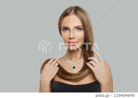 Glorious jewellery model woman wearing stylish gold necklace with green crystal emerald and diamond  119404649