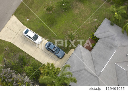 Aerial view of typical contemporary american private house with roof top covered with asphalt shingles and green lawn on yard Aerial view of typical contemporary american private house with roof top covered with asphalt shingles and green lawn on yard 119405055