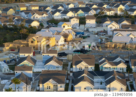 Aerial view of unfinished wooden frames of affordable houses under construction. Development of residential housing in American suburbs. Real estate market in the USA Aerial view of unfinished wooden frames of affordable houses under construction. Development of residential housing in American suburbs. Real estate market in the USA 119405056