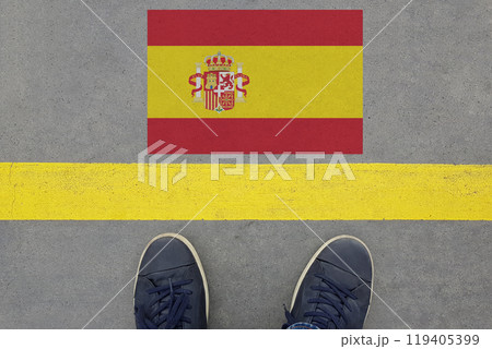 Word Start on an asphalt road with the Spanish flag  and legs in shoes. 119405399