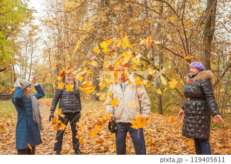Happy little girl with mom and grandmother picking up leaves in park in autumn Happy little girl with mom and grandmother picking up leaves in park in autumn 119405611