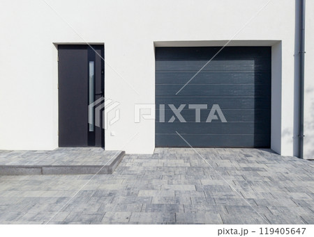 Modern garage with front door and paved entrance Modern garage with front door and paved entrance 119405647