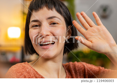 POV of young woman making online video call talking waving hand hello looking at camera blowing kiss 119406003