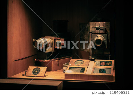 Historical cameras displayed in a museum exhibit showcasing early photography techniques and equipment from the past century 119406531