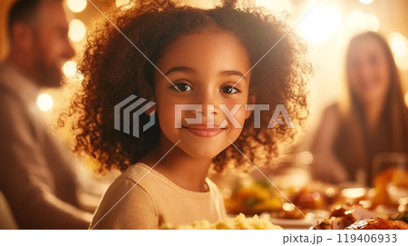 Happy Girl Enjoying a Festive Meal in a Warmly Lit Dining Room 119406933