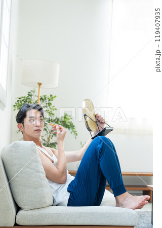 リビングでメイクをする若い男性 リビングでメイクをする若い男性 119407935