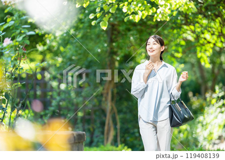 新緑の中を歩く女性 119408139