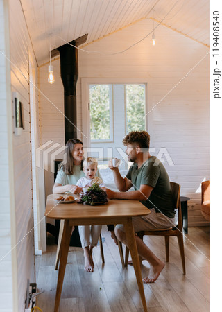 Family breakfast with coffee, croissants, and fruit in cozy, minimalist home, sharing joyful moments Family breakfast with coffee, croissants, and fruit in cozy, minimalist home, sharing joyful moments 119408540