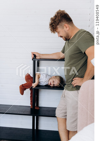 Father and son spending time together in a cozy, modern home interior with minimalist design Father and son spending time together in a cozy, modern home interior with minimalist design 119408549