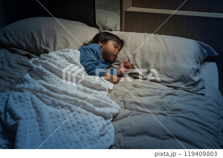 toddler baby sleeping on bed at night 119409803