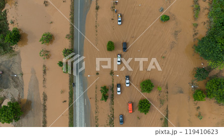 Aerial view of car driving on the road flooded during typhoon Yagi has swept Chiang Rai province of Thailand. 119410623