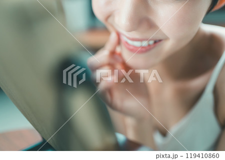 鏡の前で笑顔の練習をする若い女性 鏡の前で笑顔の練習をする若い女性 119410860