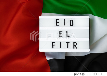Message Lightbox EID EL FITR - Eid Mubarak - Happy Holidays text frame on United Arab Emirates waving flag made from silk material. Public holiday celebration background. The National Flag of UAE Message Lightbox EID EL FITR - Eid Mubarak - Happy Holidays text frame on United Arab Emirates waving flag made from silk material. Public holiday celebration background. The National Flag of UAE 119411116