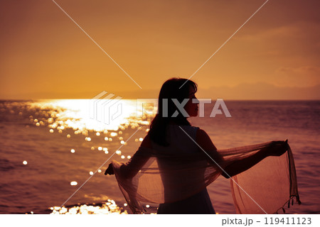 夕日の海と女性 119411123