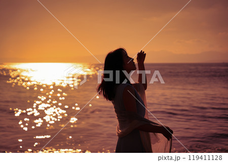 夕日の海と女性 119411128