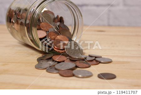 Glass Jar of American Coins on Wooden Table Glass Jar of American Coins on Wooden Table 119411707