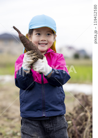 サツマイモを収穫する女の子 119412580