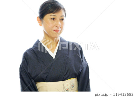 紬の着物を着て寂しそうにほほ笑む中年女性 119412682
