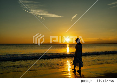夕日の海と女性 119412750