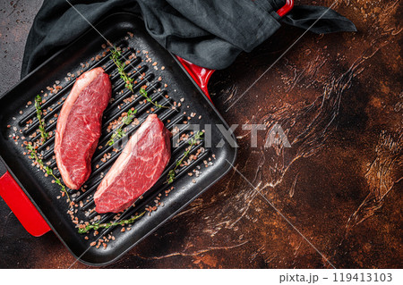 Raw Cap Rump steak, marbled beef meat on a grill skillet. Dark background. Top view. Copy space Raw Cap Rump steak, marbled beef meat on a grill skillet. Dark background. Top view. Copy space 119413103