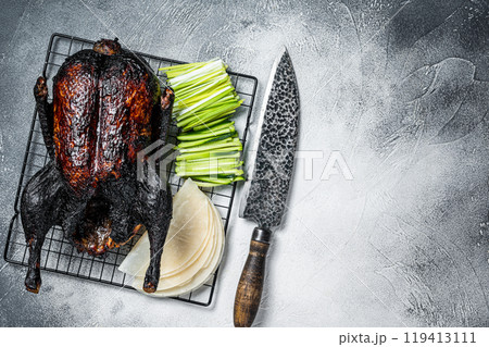 Whole roast Peking duck with herbs, sauce, rice Pancake, Cucumber and onion. White background. Top view. Copy space 119413111
