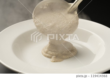 きのこのポタージュ ポタージュをお玉で皿に盛り付ける きのこのポタージュ ポタージュをお玉で皿に盛り付ける 119414368