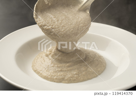 きのこのポタージュ　ポタージュをお玉で皿に盛り付ける 119414370