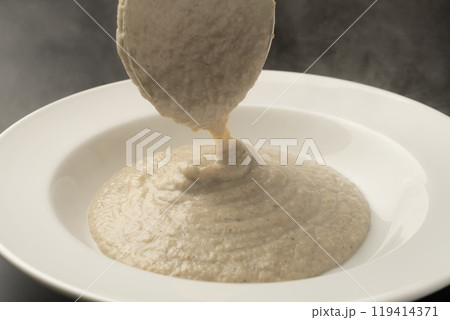 きのこのポタージュ　ポタージュをお玉で皿に盛り付ける 119414371