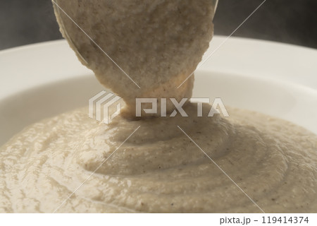 きのこのポタージュ　ポタージュをお玉で皿に盛り付ける 119414374