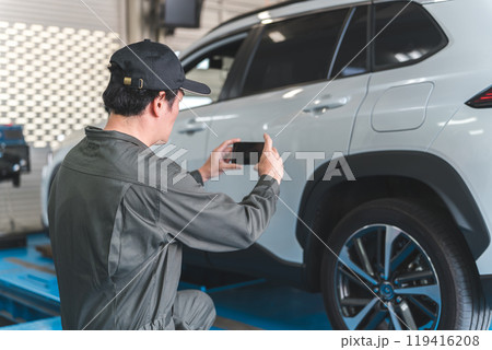 預り車両をスマホで写真を撮る整備士の男性 預り車両をスマホで写真を撮る整備士の男性 119416208