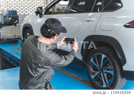 預り車両をスマホで写真を撮る整備士の男性 預り車両をスマホで写真を撮る整備士の男性 119416209