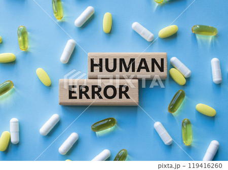 Human Error symbol. Concept word Human Error on wooden blocks. Beautiful blue background with pills. Medicine and Human Error concept. Copy space Human Error symbol. Concept word Human Error on wooden blocks. Beautiful blue background with pills. Medicine and Human Error concept. Copy space 119416260