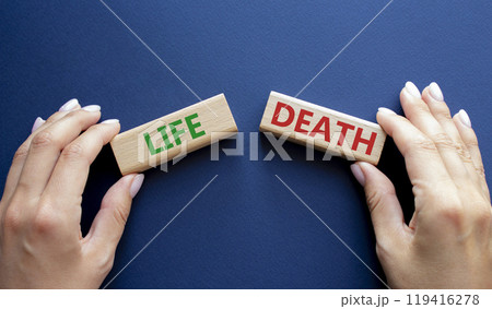 Life or Death symbol. Concept word Life or Death on wooden blocks. Businessman hand. Beautiful deep blue background. Business and Life or Death concept. Copy space 119416278