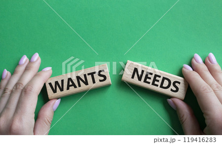 Wants and Needs symbol. Concept word Wants and Needs on wooden blocks. Businessman hand. Beautiful green background. Business and Wants and Needs concept. Copy space 119416283