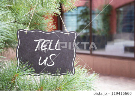 Tell us symbol. Concept words Tell us on black chalk blackboard. Beautiful background with shop and tree. Business and Tell us concept. Copy space. 119416660