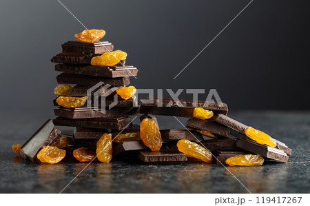 Broken dark chocolate bar with raisins. 119417267