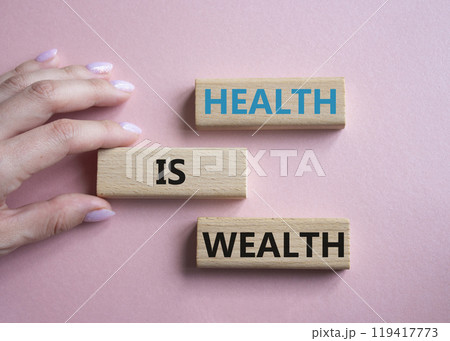 Health is Wealth symbol. Concept word Health is Wealth on wooden blocks. Doctor hand. Beautiful pink background. Medicine and Health is Wealth concept. Copy space 119417773