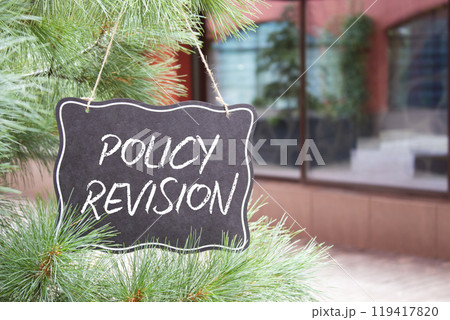 Policy revision symbol. Concept words Policy revision on black chalk blackboard. Beautiful background with shop and tree. Business and Policy revision concept. Copy space. Policy revision symbol. Concept words Policy revision on black chalk blackboard. Beautiful background with shop and tree. Business and Policy revision concept. Copy space. 119417820
