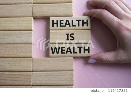 Health is Wealth symbol. Concept word Health is Wealth on wooden blocks. Doctor hand. Beautiful pink background. Medicine and Health is Wealth concept. Copy space 119417821