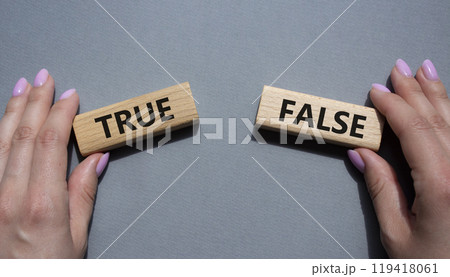 True or False symbol. Concept word True or False on wooden blocks. Businessman hand. Beautiful grey background. Business and True or False concept. Copy space True or False symbol. Concept word True or False on wooden blocks. Businessman hand. Beautiful grey background. Business and True or False concept. Copy space 119418061