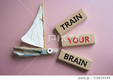 Train Your Brain symbol. Concept words Train Your Brain on wooden blocks. Beautiful pink background with boat. Healthcare and Train Your Brain concept. Copy space. 119418149