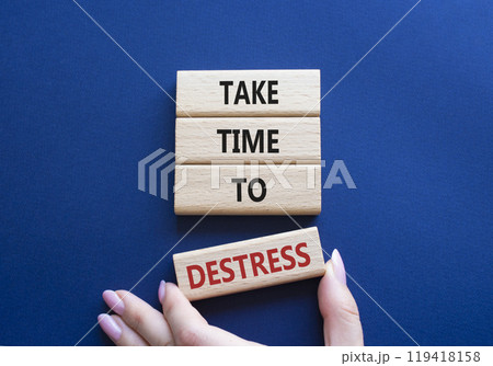 Take time to Destress symbol. Wooden blocks with words Take time to Destress. Beautiful deep blue background. Businessman hand. Business and Take time to Destress concept. Copy space. 119418158