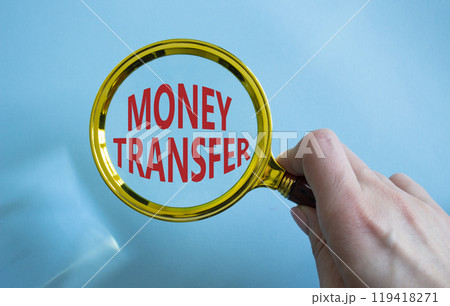 Money Transfer symbol. Magnifying Glass with Concept word Money Transfer. Businessman hand. Beautiful blue background. Business and Money Transfer concept. Copy space Money Transfer symbol. Magnifying Glass with Concept word Money Transfer. Businessman hand. Beautiful blue background. Business and Money Transfer concept. Copy space 119418271