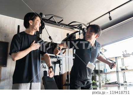 パーソナルジムで会員にトレーニングの見本を見せるトレーナーの男性（胸トレ） 119418751