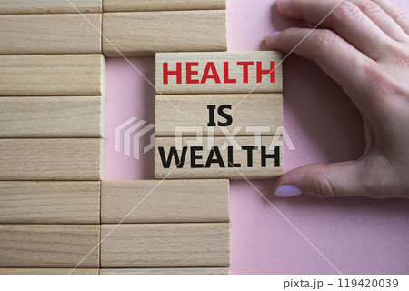 Health is Wealth symbol. Concept word Health is Wealth on wooden blocks. Doctor hand. Beautiful pink background. Medicine and Health is Wealth concept. Copy space Health is Wealth symbol. Concept word Health is Wealth on wooden blocks. Doctor hand. Beautiful pink background. Medicine and Health is Wealth concept. Copy space 119420039