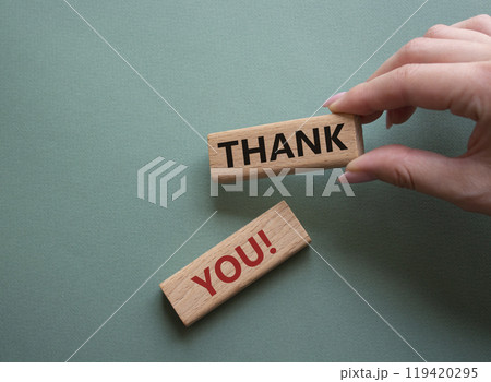 Thank you symbol. Wooden blocks with words Thank you. Businessman hand. Beautiful grey green background. Business and Thank you concept. Copy space. Thank you symbol. Wooden blocks with words Thank you. Businessman hand. Beautiful grey green background. Business and Thank you concept. Copy space. 119420295