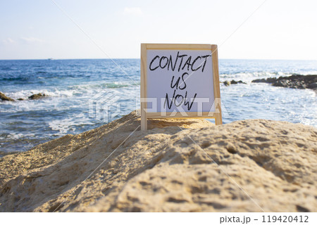 Contact us now symbol. White Blackboard with words Contact us now. Beautiful sea background. Business and Contact us now concept. Copy space. Contact us now symbol. White Blackboard with words Contact us now. Beautiful sea background. Business and Contact us now concept. Copy space. 119420412