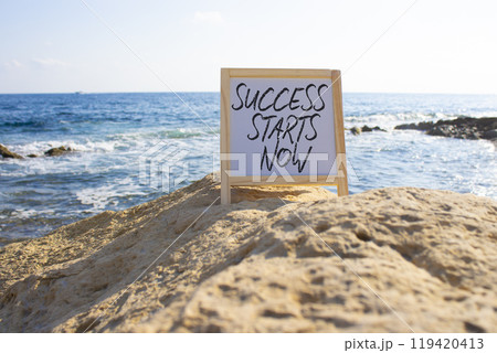 Success Starts Now symbol. Concept words Success Starts Now on white chalk blackboard. Beautiful sea background. Psychological social and Success Starts Now concept. Copy space. Success Starts Now symbol. Concept words Success Starts Now on white chalk blackboard. Beautiful sea background. Psychological social and Success Starts Now concept. Copy space. 119420413