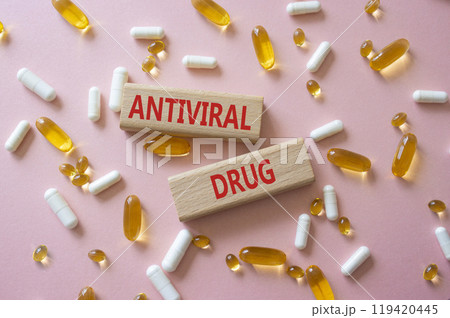 Antiviral Drug symbol. Concept words Antiviral Drug on wooden blocks. Beautiful pink background with pills. Medicine and Antiviral Drug concept. Copy space. Antiviral Drug symbol. Concept words Antiviral Drug on wooden blocks. Beautiful pink background with pills. Medicine and Antiviral Drug concept. Copy space. 119420445
